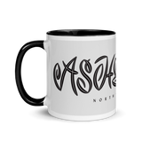 white coffee mug with "Asheville" written in custom lettering. Black interior and handle.
